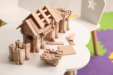 Wooden entry gate and building blocks on white table indoors. Children's toy