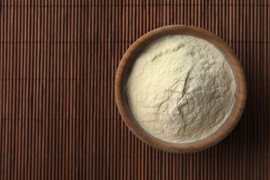 Photo of Bowl of agar-agar powder on bamboo mat, top view. Space for text