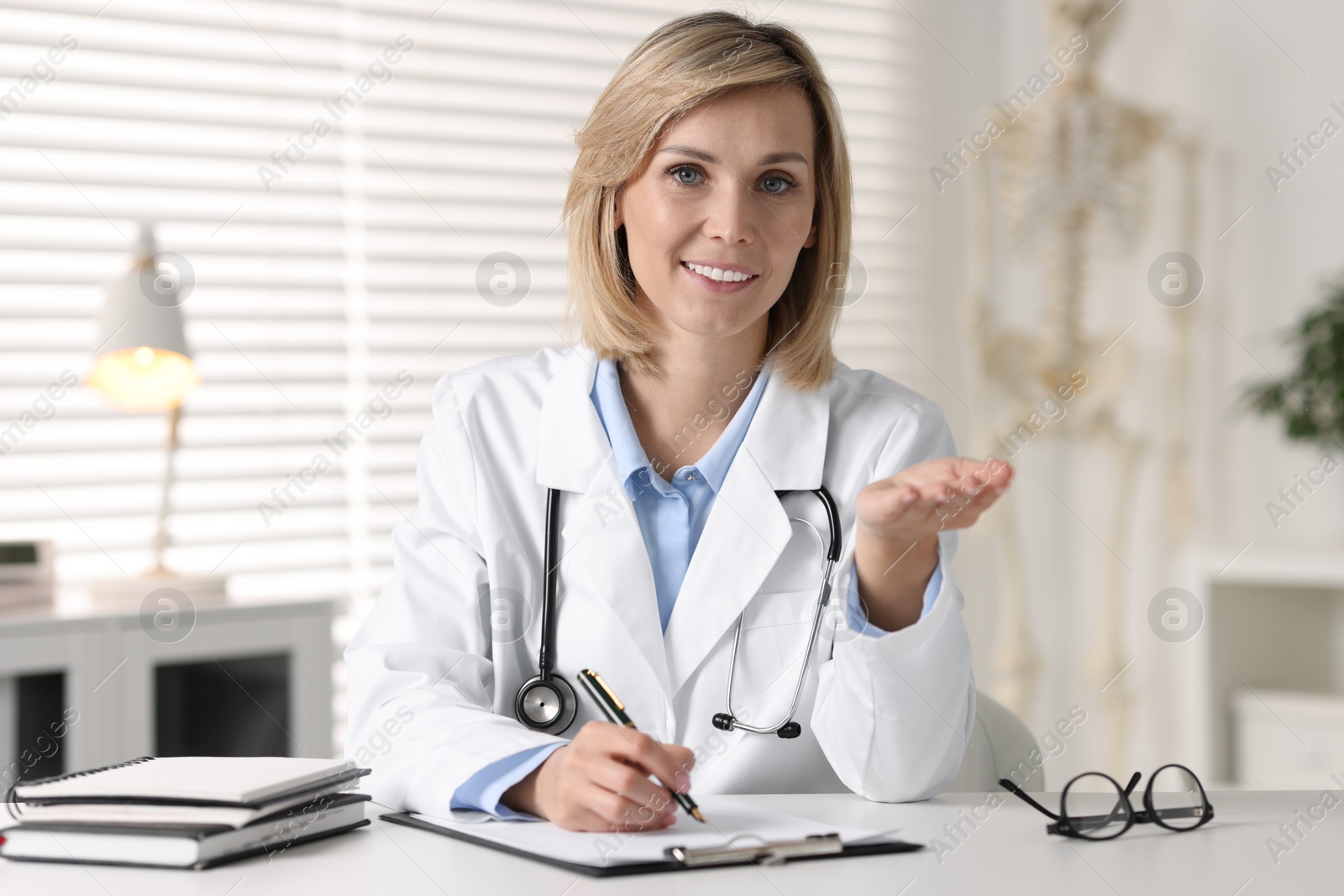 Photo of Portrait of smiling doctor at table in office