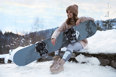 Young snowboarder wearing winter sport clothes outdoors