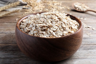 Photo of Bowl with oatmeal on wooden table, closeup