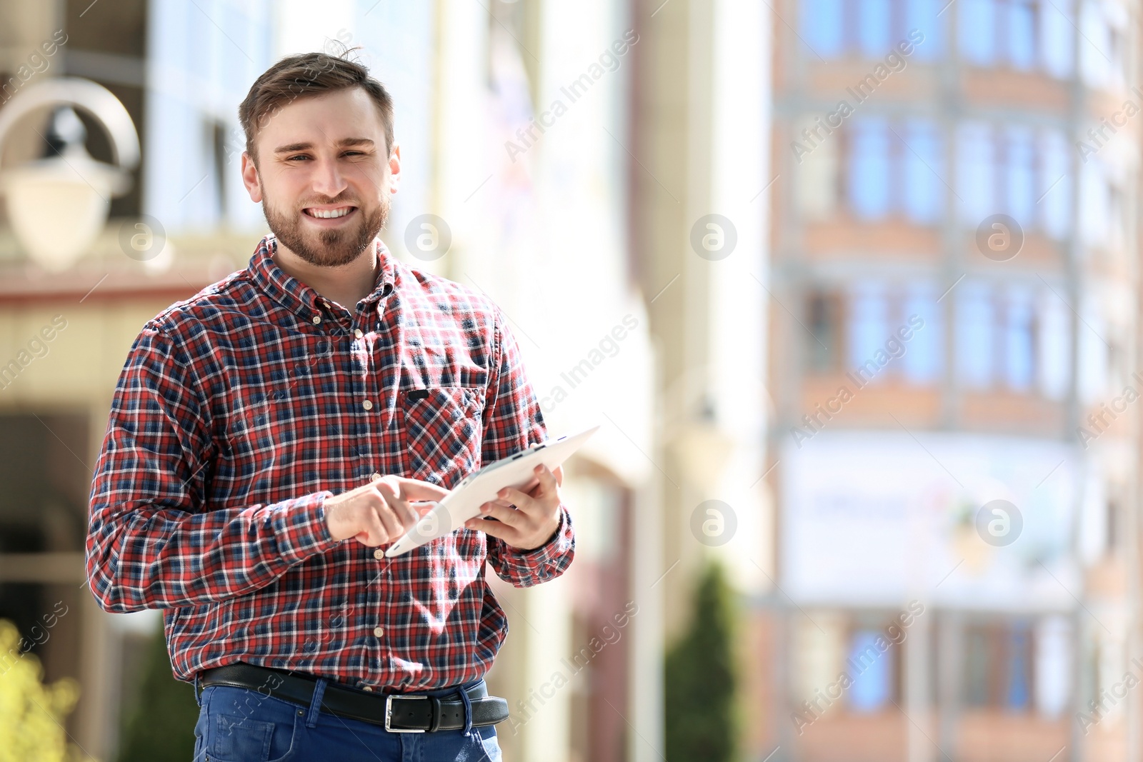 Photo of Portrait of young man with tablet outdoors