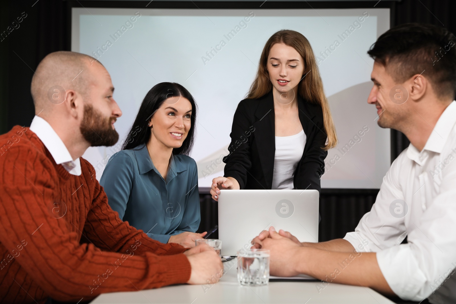 Photo of Business people having meeting in conference room with video projection screen