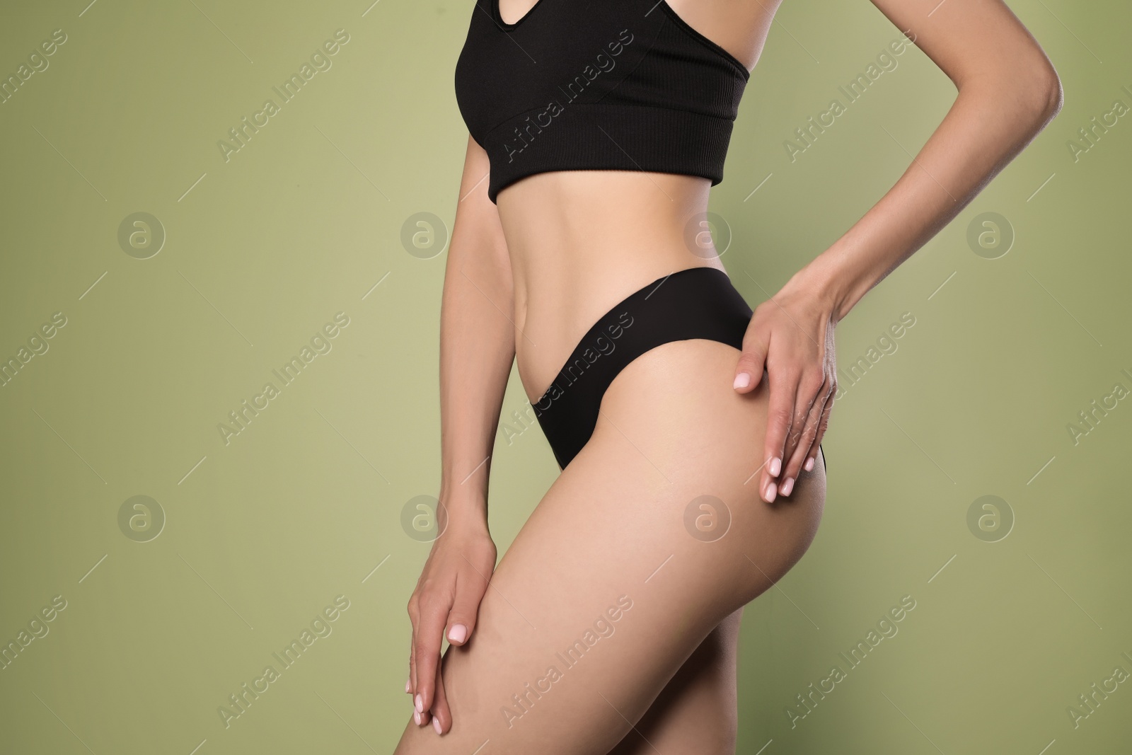 Photo of Closeup view of slim woman in underwear on light green background. Cellulite problem concept