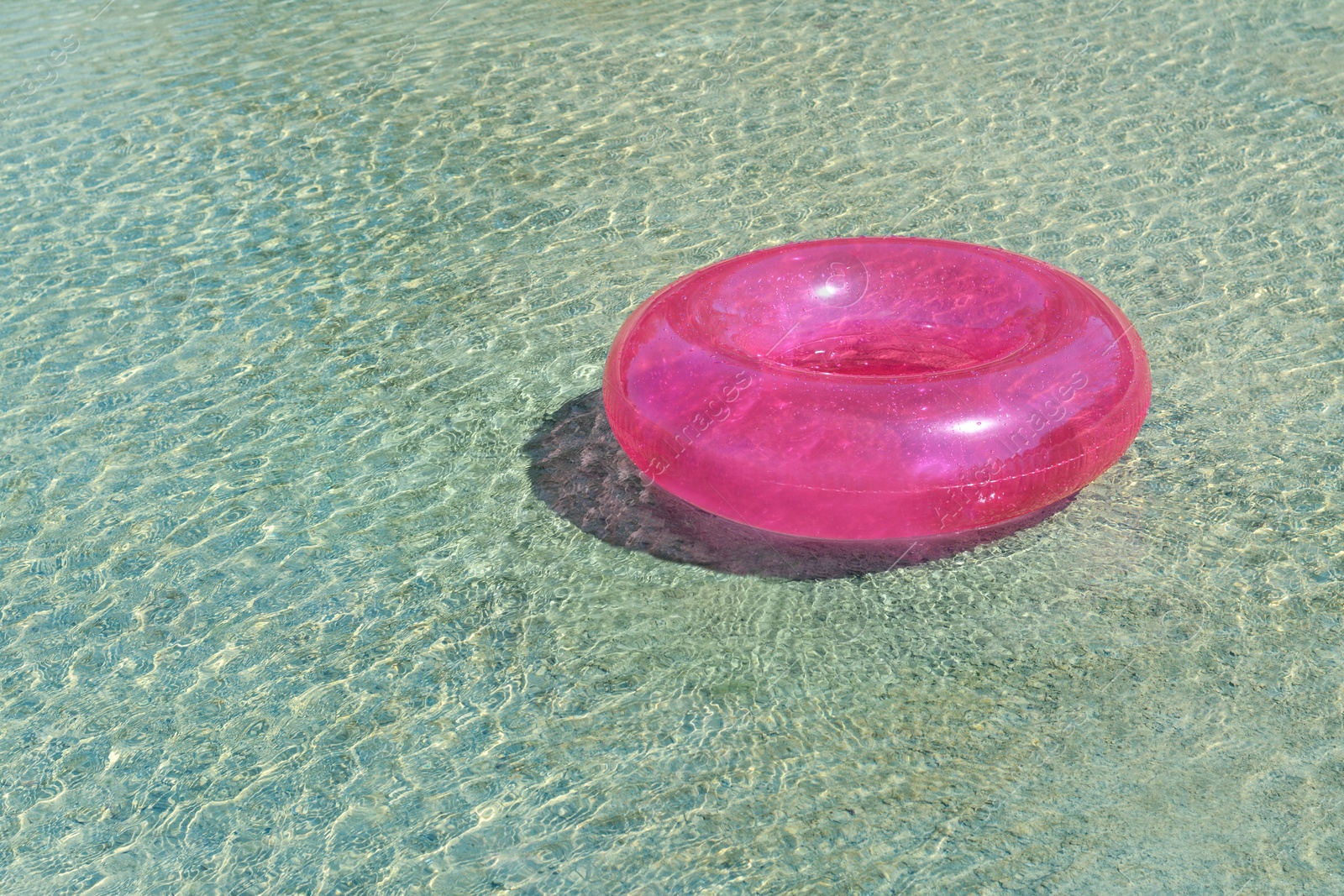 Photo of Bright inflatable ring floating on sea water. Space for text