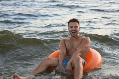 Happy young man on inflatable ring in water