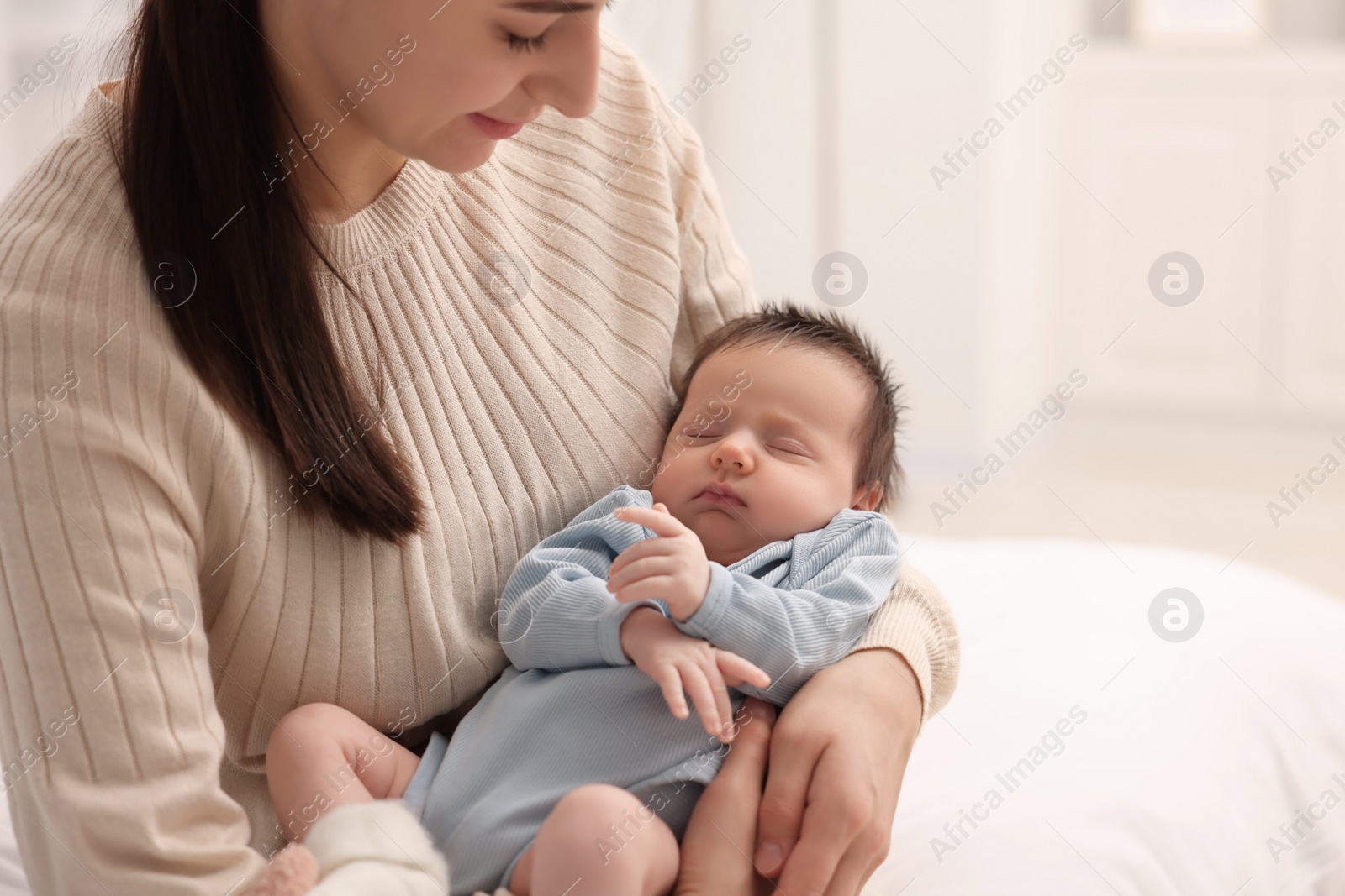 Photo of Mother with her sleeping newborn baby at home, closeup. Space for text