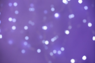 Photo of Beautiful snowflake shaped lights on purple background
