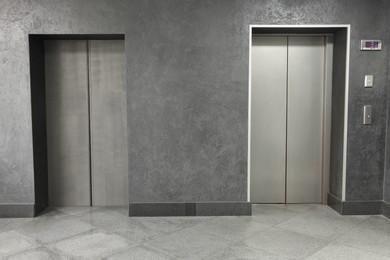 Closed stylish elevator doors in clean hall