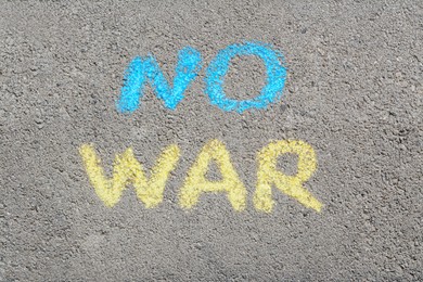 Words No War written with blue and yellow chalks on asphalt outdoors, top view