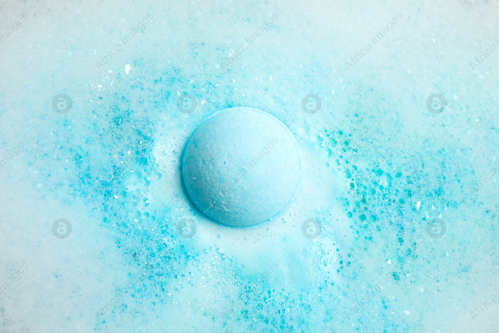 Photo of Color bath bomb dissolving in water, top view