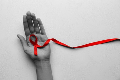 Image of World AIDS disease day. Woman holding red awareness ribbon on white background, top view with space for text 