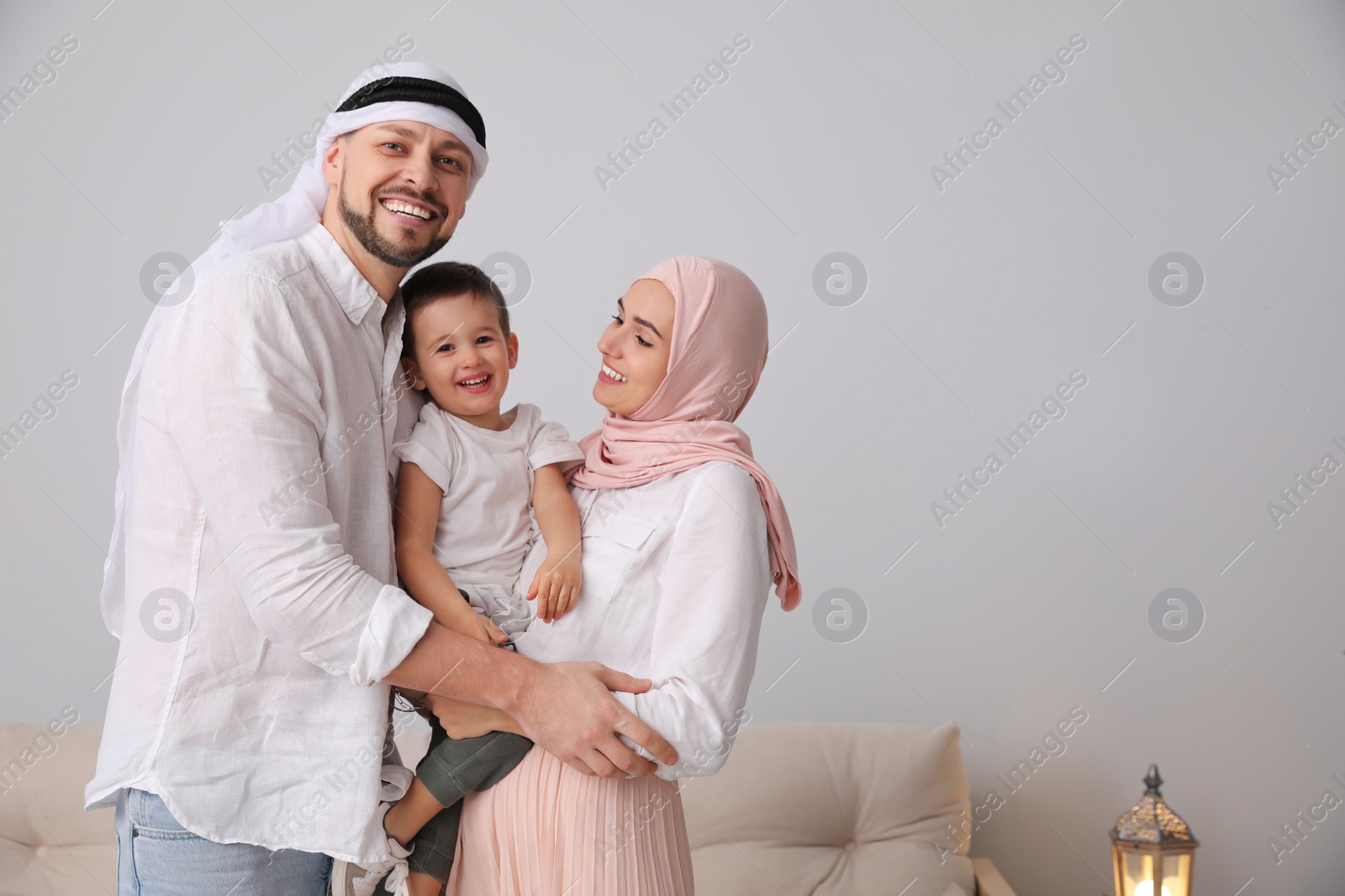 Photo of Happy Muslim family spending time together at home, space for text