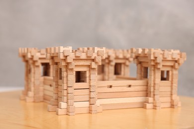Wooden fortress on table against grey background. Children's toy