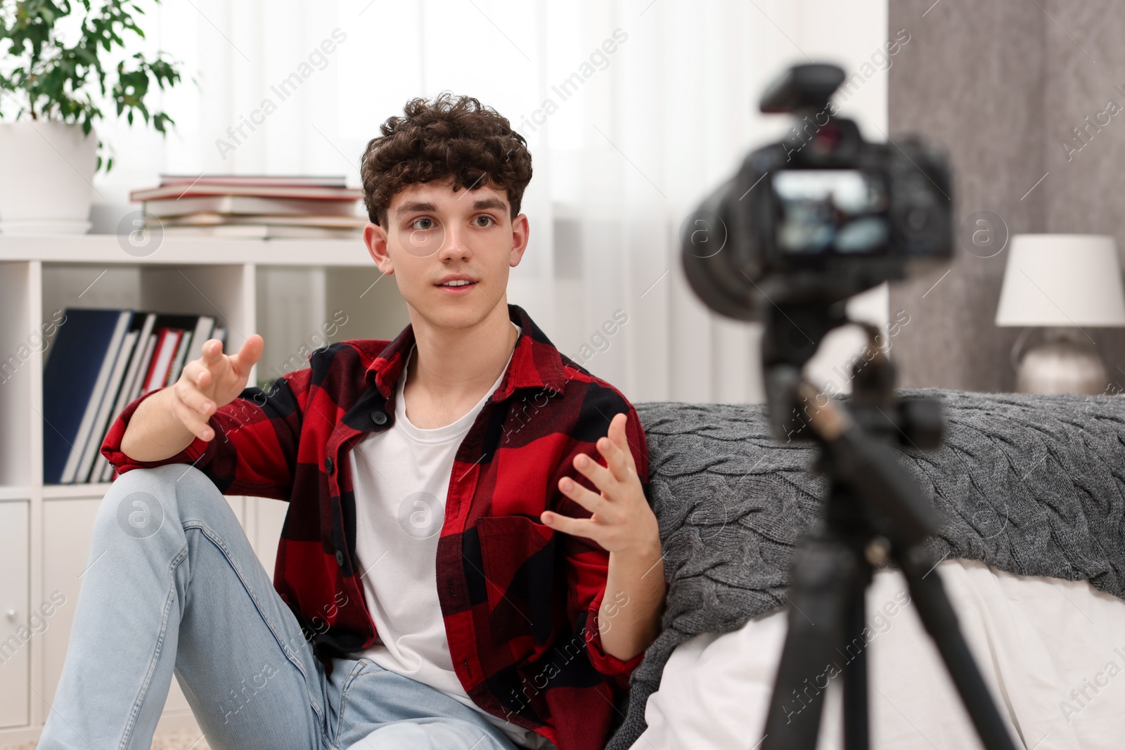 Photo of Teenage blogger explaining something while streaming at home