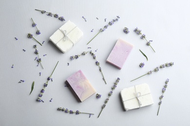 Photo of Hand made soap bars with lavender flowers on white background, top view