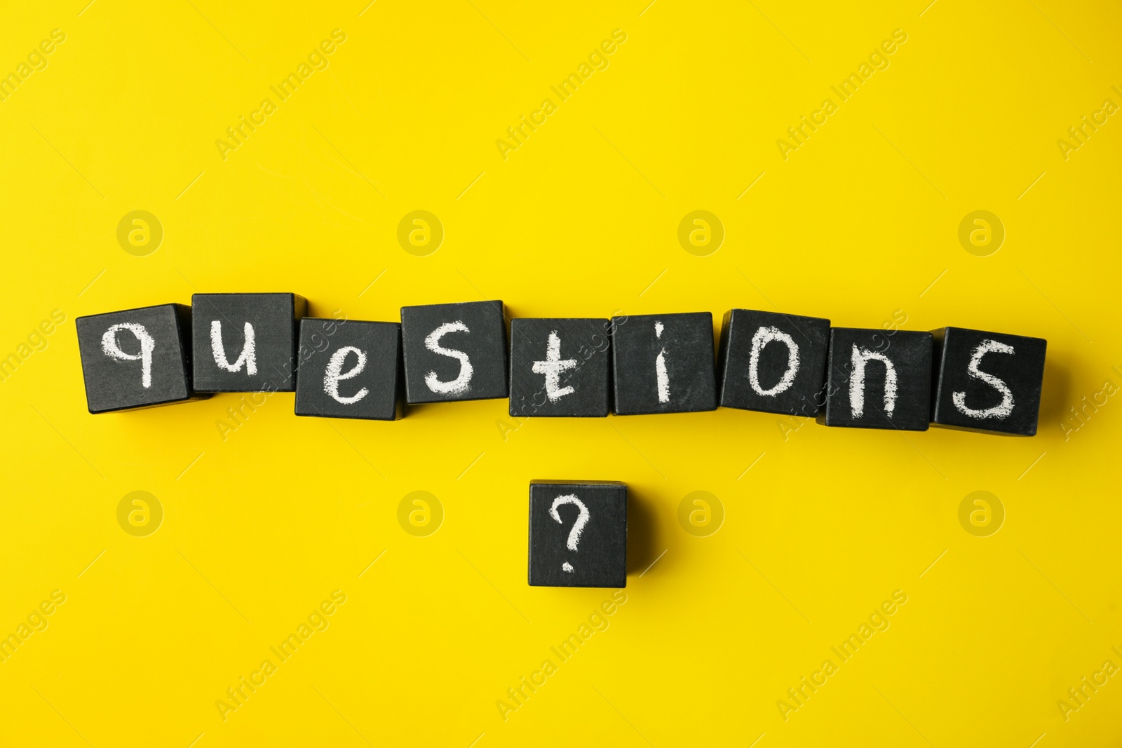 Photo of Word QUESTIONS and query mark with black cubes on yellow background, flat lay