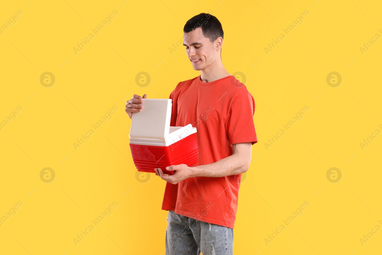 Photo of Man with red cool box on orange background