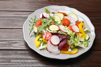 Photo of Balanced diet and vegetarian foods. Plate with different delicious products on wooden table. Space for text