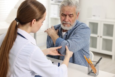 Photo of Arthritis symptoms. Doctor examining patient's elbow in hospital