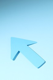 Photo of One paper arrow on light blue background, space for text
