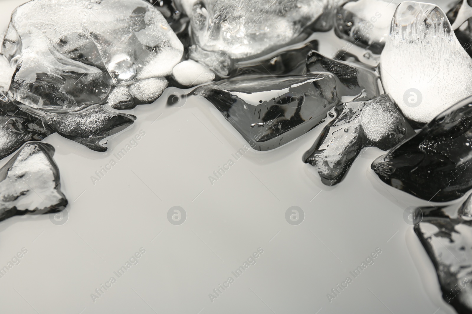 Photo of Pieces of crushed ice on grey background, space for text
