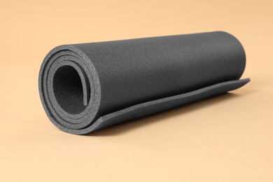 Photo of One grey yoga mat on beige background