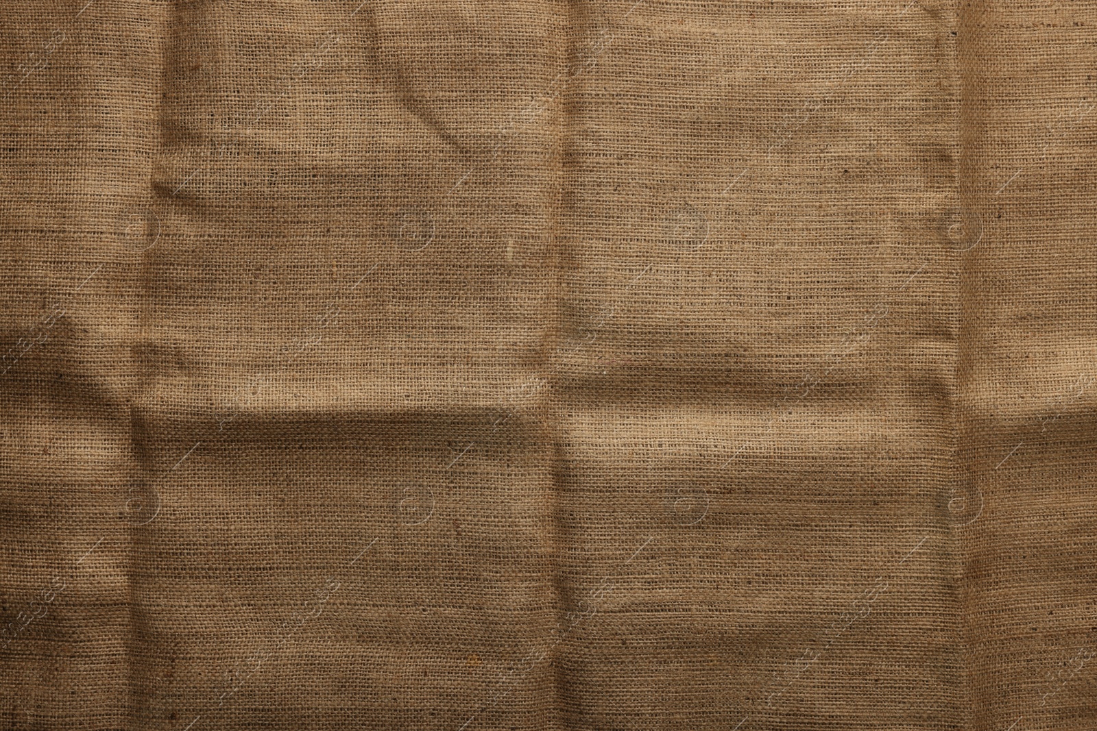 Photo of Texture of natural burlap fabric as background, top view