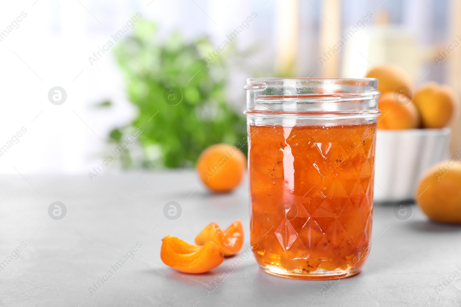 Photo of Jar with tasty apricot jam on table