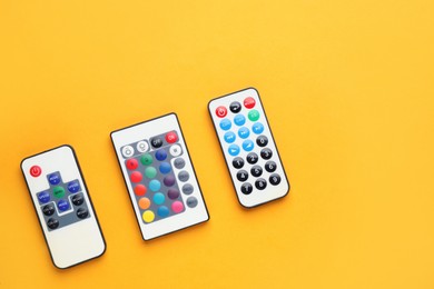 Photo of Remote controls on yellow background, flat lay. Space for text