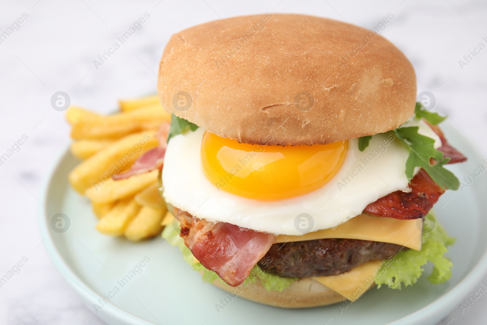 Photo of Delicious burger with fried egg and french fries served on white marble table, closeup