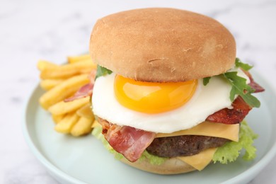 Photo of Delicious burger with fried egg and french fries served on white marble table, closeup