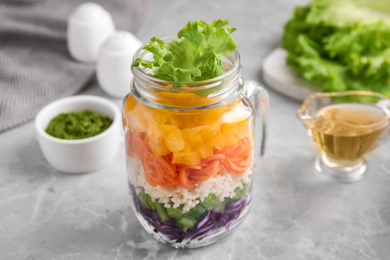 Photo of Healthy salad in glass jar on marble table