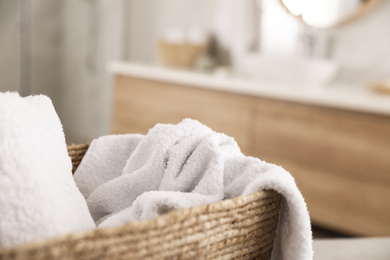 Wicker basket with clean towels in bathroom, closeup