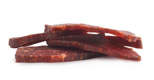 Pieces of delicious beef jerky on white background