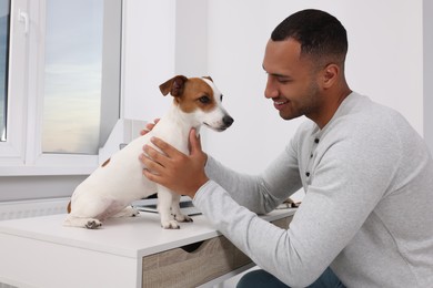 Young man with Jack Russell Terrier at desk in home office