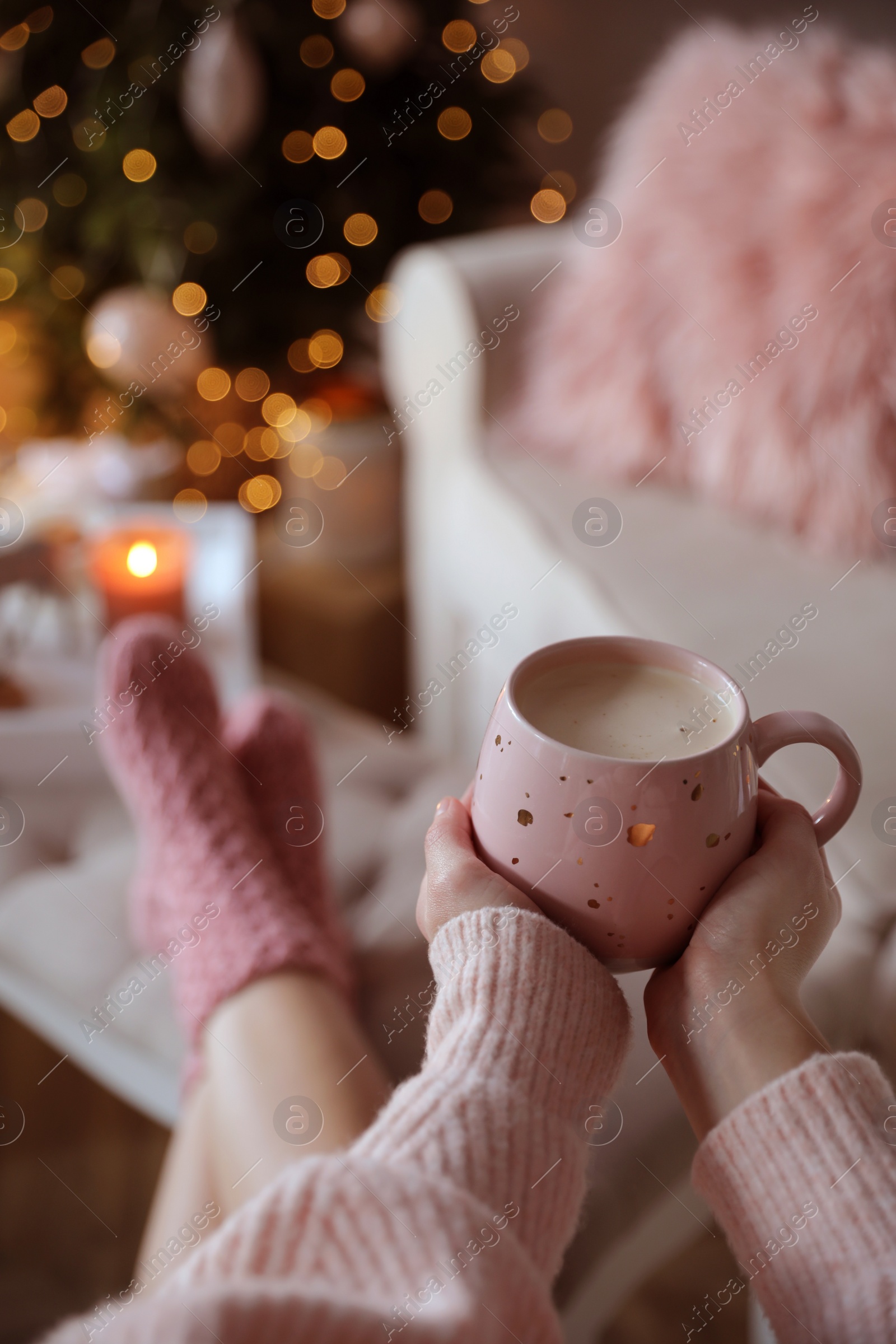 Photo of Woman holding cup of cocoa at home, closeup. Christmas mood