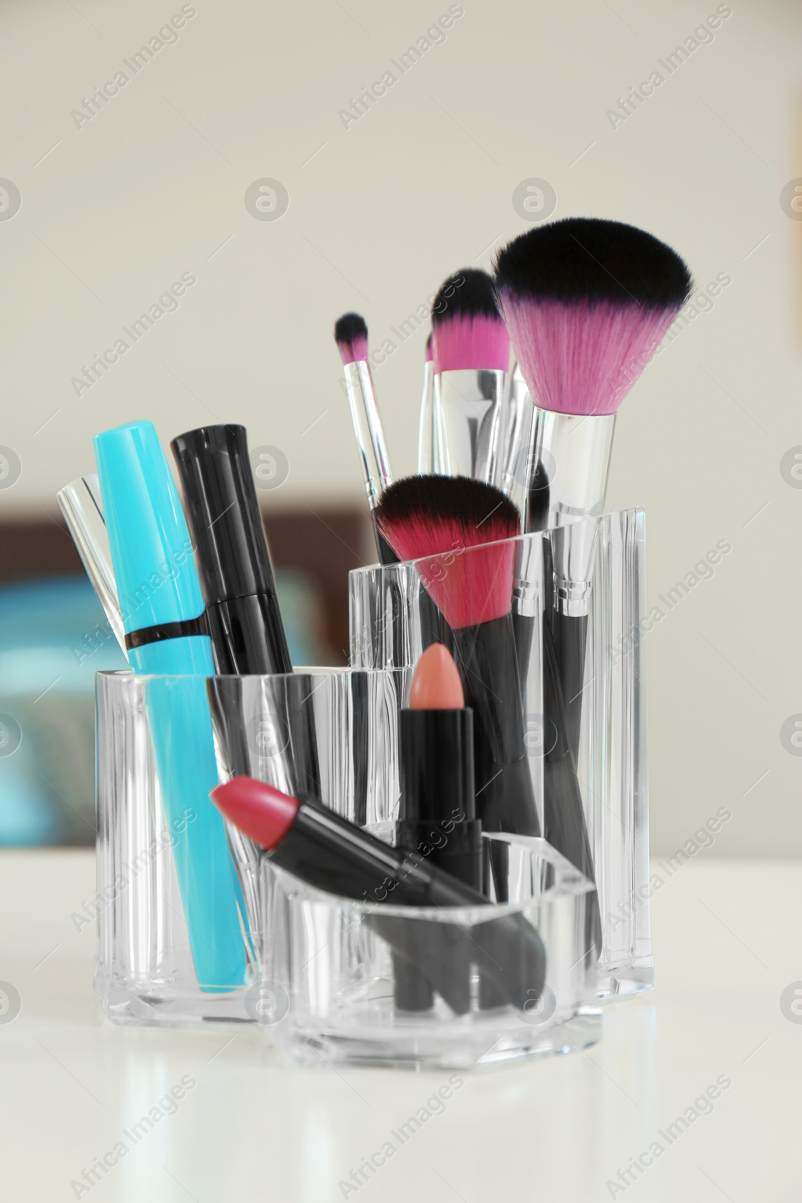 Photo of Organizer with cosmetic products for makeup on table indoors