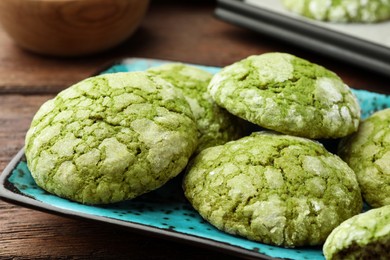 Plate with tasty matcha cookies on wooden table, closeup