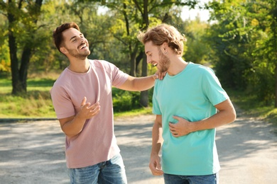 Happy gay couple having fun in park