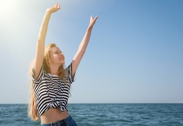 Photo of Beautiful young woman dancing near sea on sunny day in summer