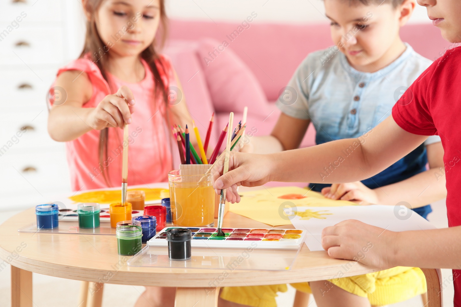 Photo of Cute little children painting at table in playing room