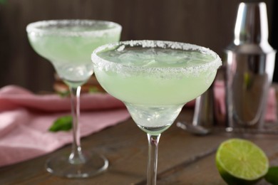 Delicious Margarita cocktail in glasses on table, closeup