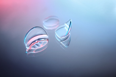 Photo of Contact lenses on color glass background