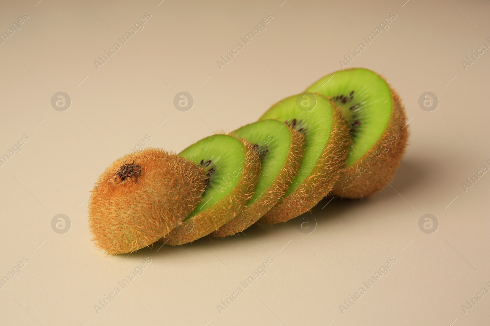 Photo of Sliced fresh ripe kiwi on beige background