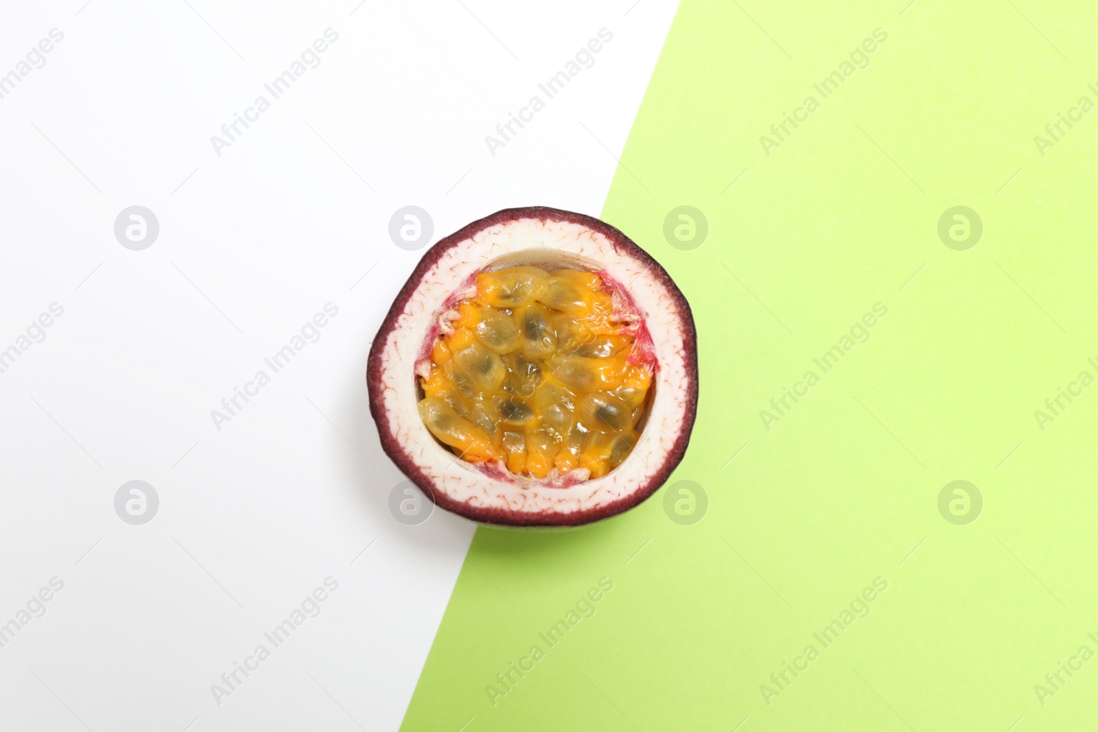 Photo of Half of tasty passion fruit (maracuya) on color background, top view