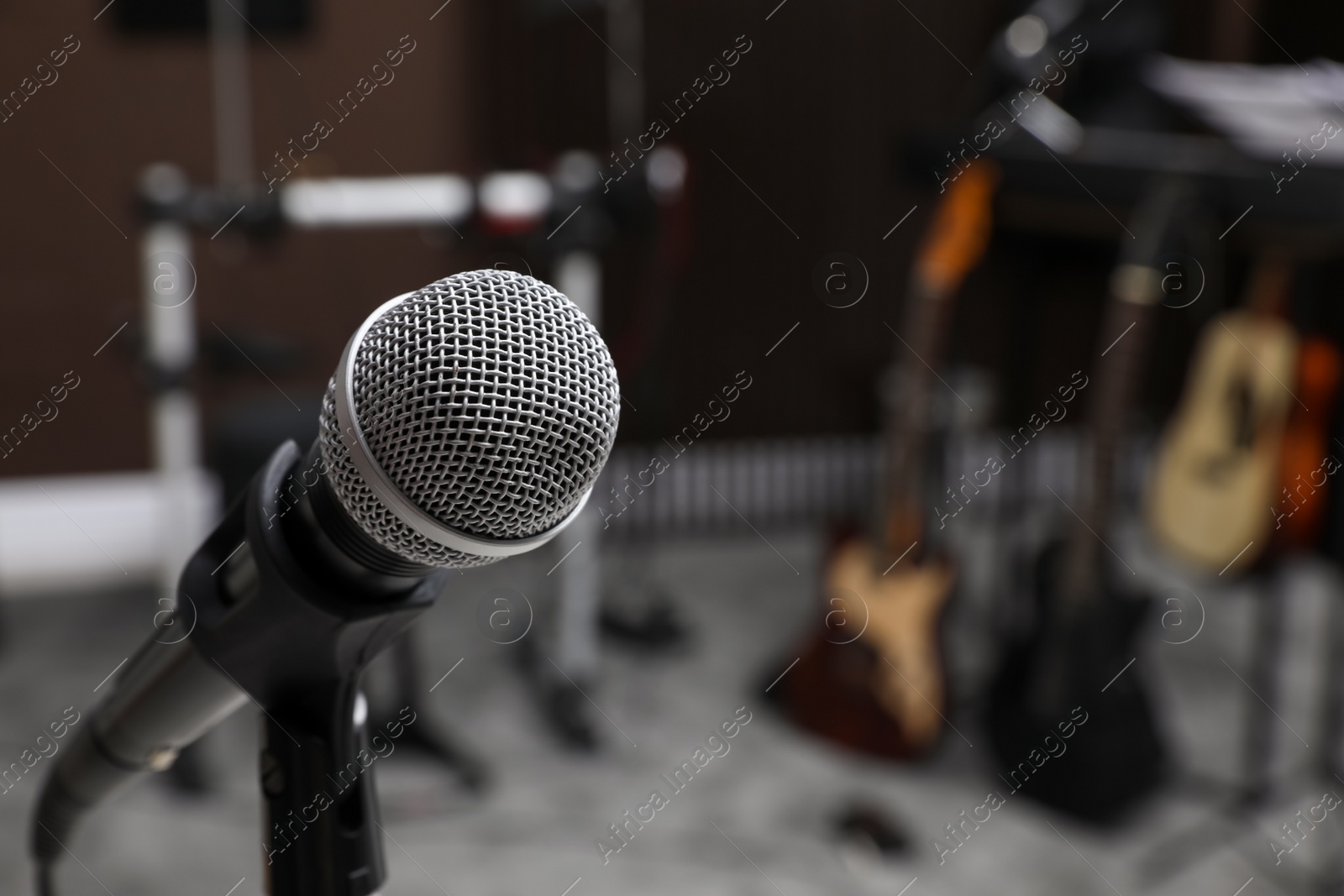 Photo of Modern microphone at recording studio, space for text. Music band practice