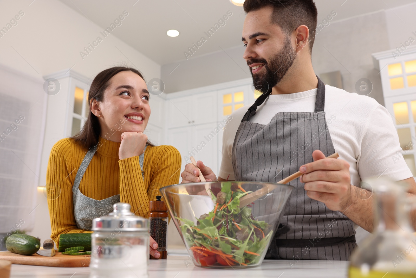 Photo of Lovely couple cooking together in kitchen, low angle view