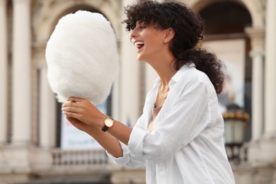 Photo of Beautiful woman with cotton candy on city street