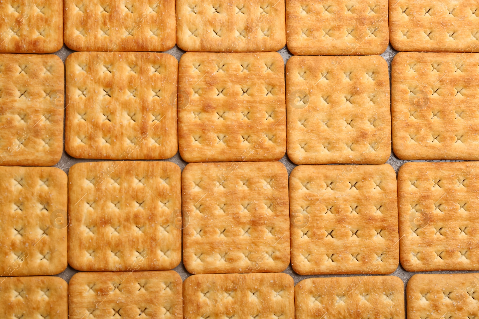 Photo of Many delicious crackers as background, top view